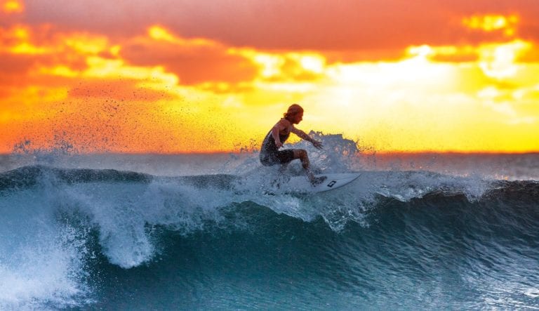 guy surfing at sunrise