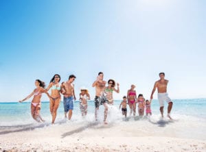 Large group of people running on the beach.