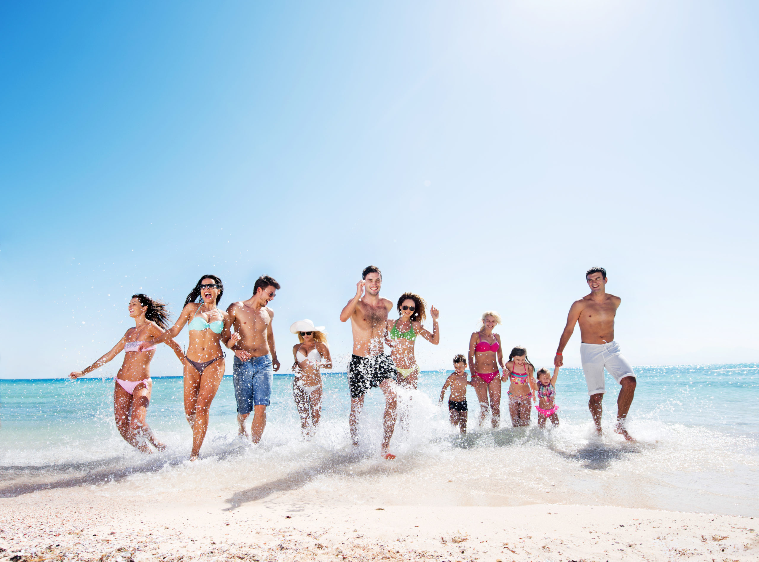 Large group of people running on the beach.